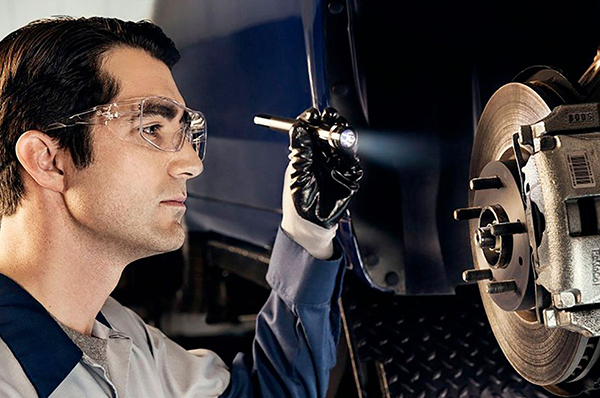 Bison Ford Service Offer - Brake Inspection Ford Tech Performing Brake Inspection