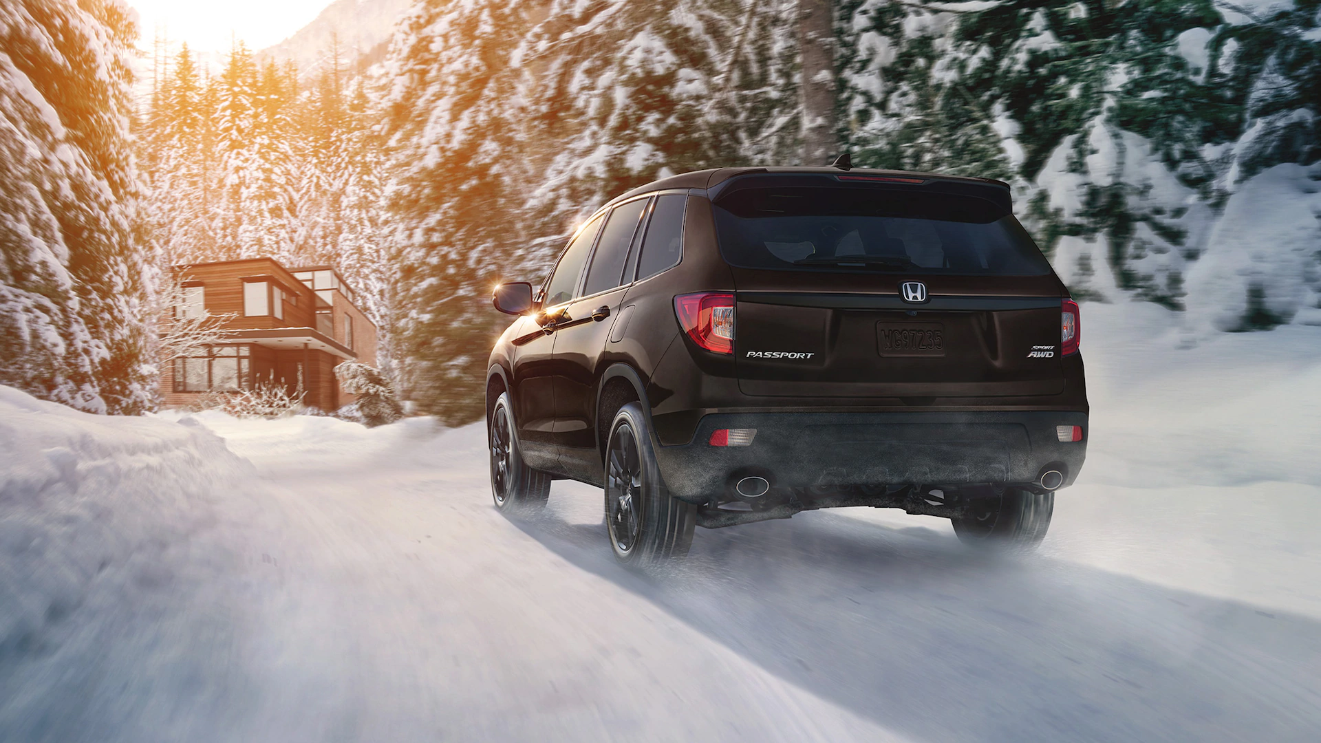2021 Honda Passport Capability AWD Sport shown in Black Copper Pearl dirving through snow