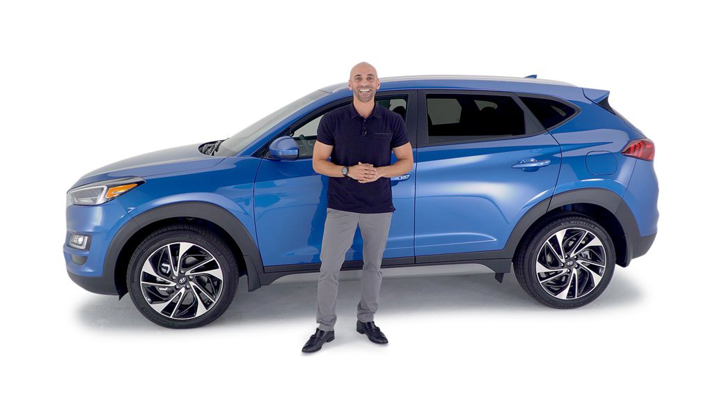 Man standing in fron of blue Tucson