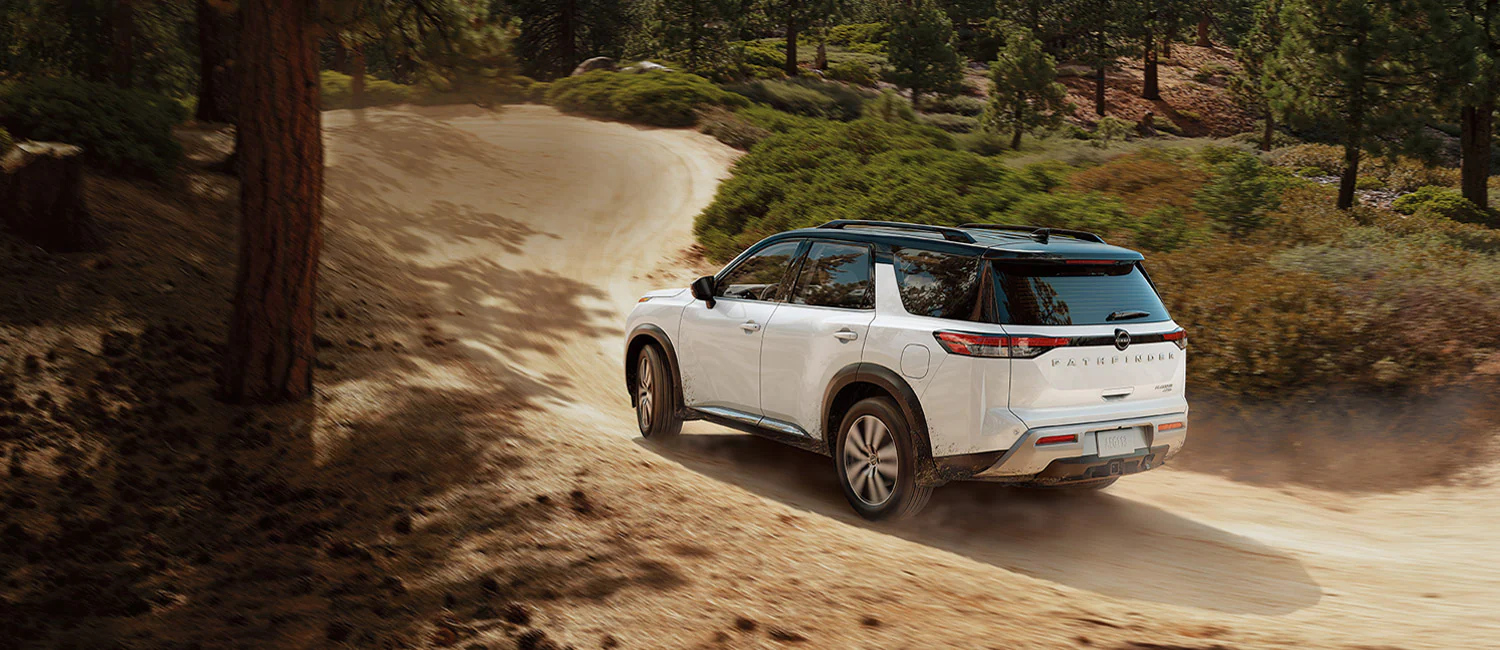 2022 Nissan Frontier Performance Frontier towing a kayak trailer through the woods