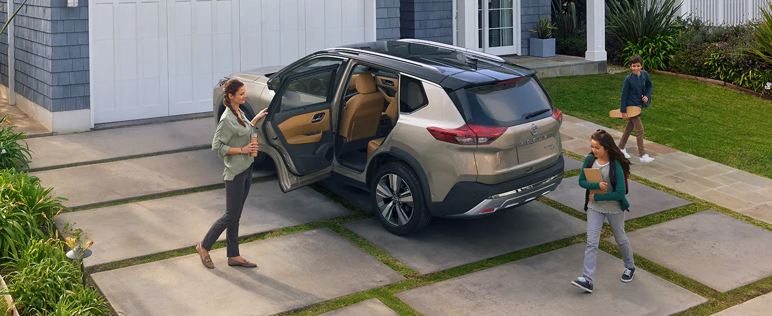 2022 Nissan Rogue Safety Rogue parked in driveway with family approaching vehicle