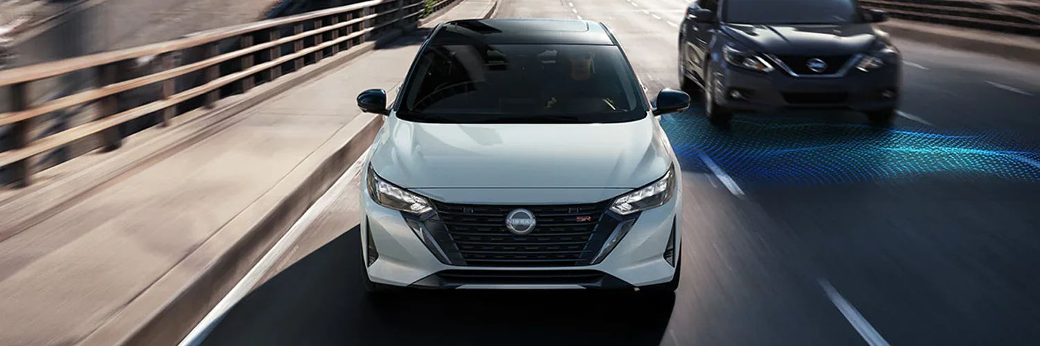 2024 Nissan Sentra Safety Sentra driving down the road using rear cross traffic alert