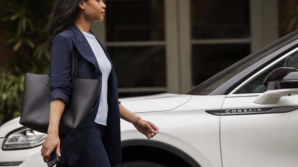 Woman approaching her Lincoln parked in driveway