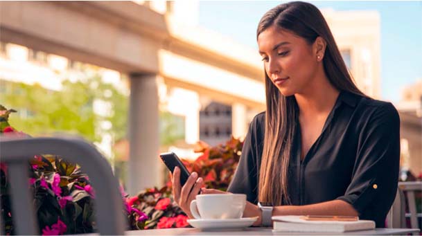 Woman sitting at table using app on phone