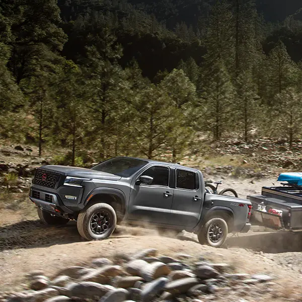 Frontier towing a trailer through the woods