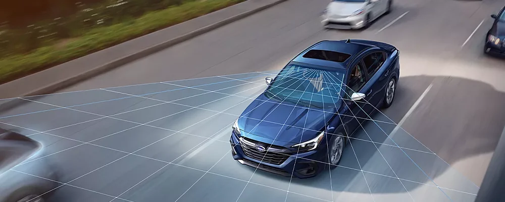 A blue Subaru Legacy projects a grid onto traffic representing EyeSight Driver Assist Technology.