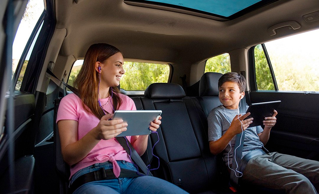 Back-seated children holding tablet devices in hands