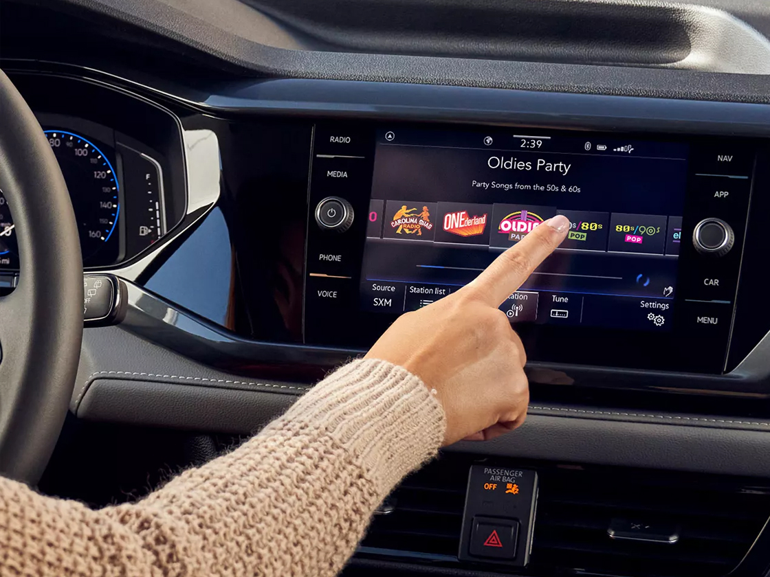 Woman in driver's seat choosing an app via the touchscreen